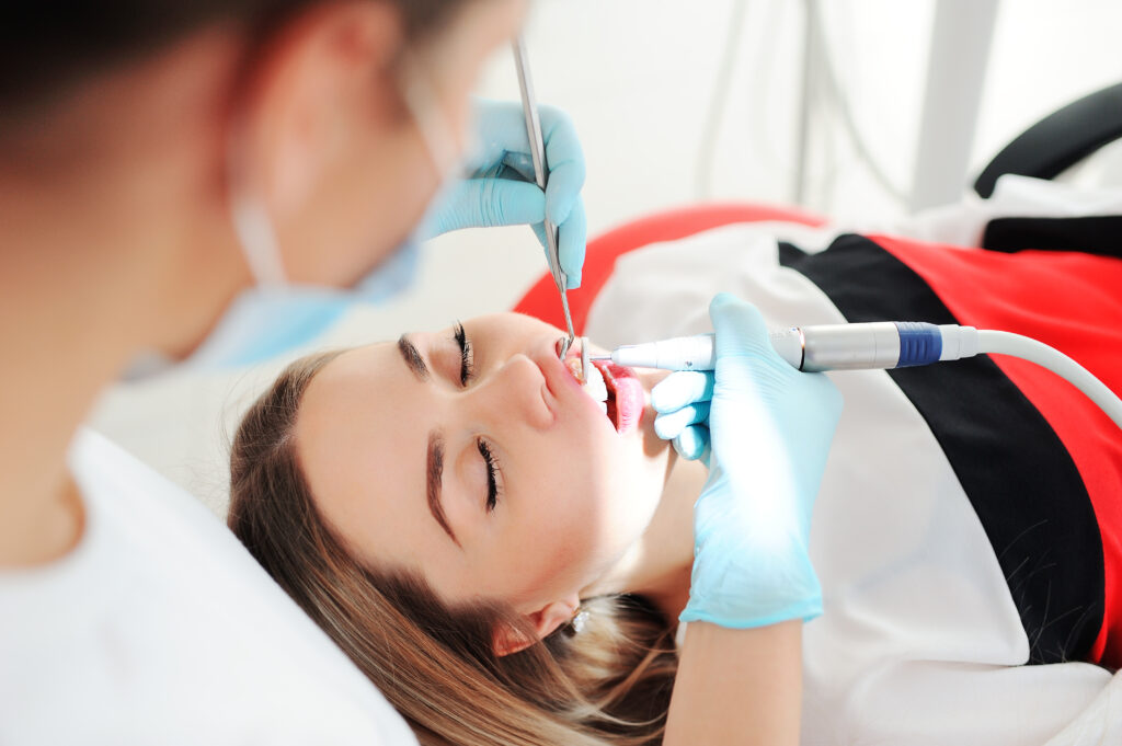 Dentist treats teeth to a patient - a beautiful young girl